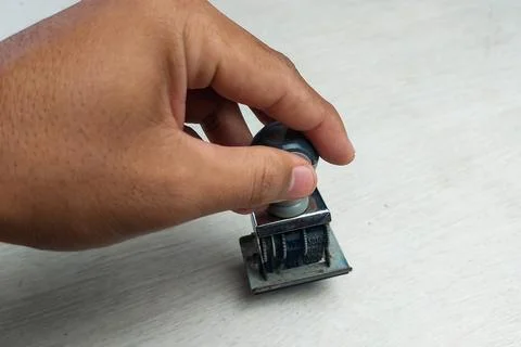 Date Stamp in Hand on White Table 스톡 사진