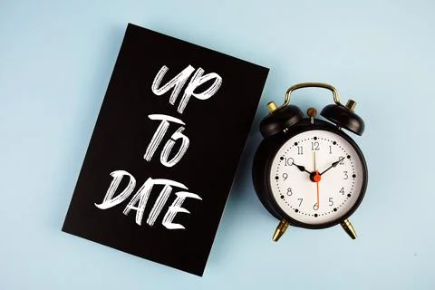 Up To Date text with alarm clock on blue background Stockfoto's