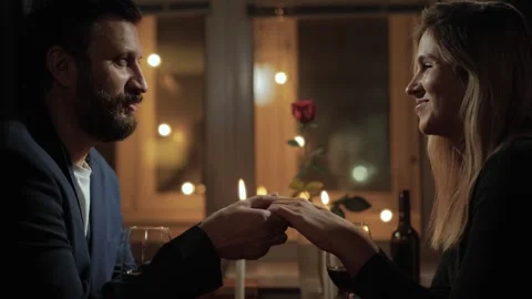 Date, Valentines Day, proposal. Man and woman hold hands during romantic dinner 库存影片 256414406