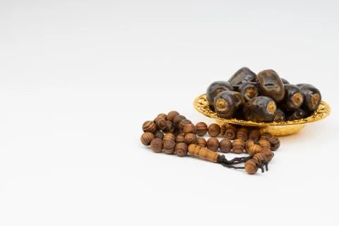 Dates and Rosary on white background Foto stock