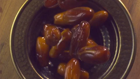 Dates fall down into copper dish in slow motion. Stock Footage 147224641