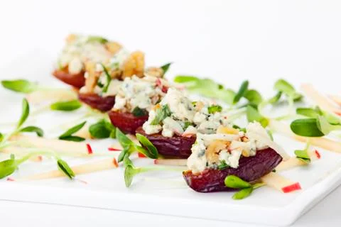 Dates filled with blue cheese, walnuts on white plate on white background. food Stock Photos