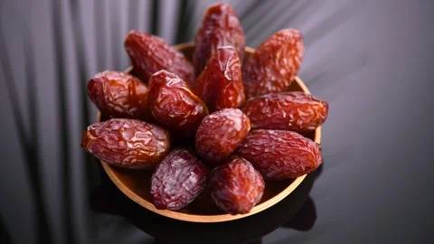 Dates fruit. Medjool Date fruits with palm tree leaf reflections on black Stock Footage 319357687