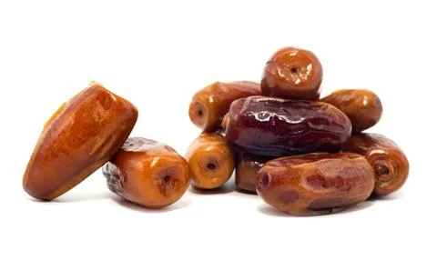 Dates isolate. Dates spill out from a cup in the shape of a heart on a white Stock Photos