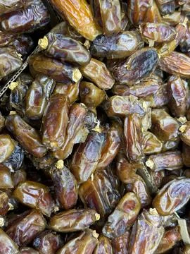 Dates piled together in abundance, showcasing texture and natural pattern b.. Foto stock