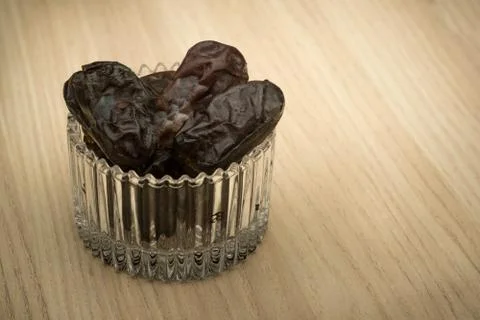 Dates in a small glass container with the sun flare.  Stock Photos