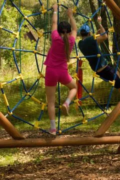 Daughter and her dad climb at ropes in rope park. Stock Photos