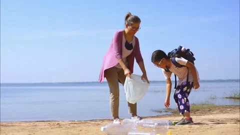 Daughter and mother collected plastic bottles by the lake Stock Footage