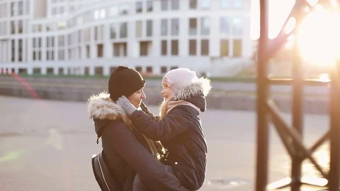 The daughter carefully puts on warm hat her mother at sunset. Video stock 81382425