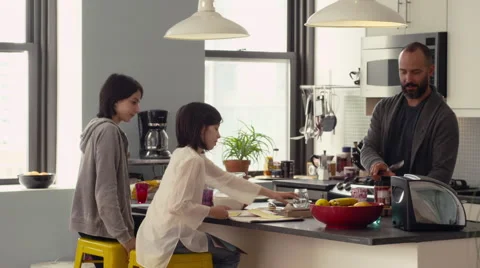 Daughter doing her homework while father working in kitchen Stock Footage 63860879