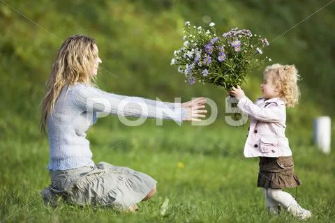 Daughter Giving Mother Bunch Of Flowers, Side View
