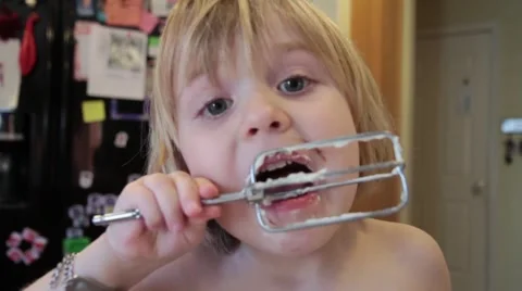 Daughter Having Fun in Kitchen Licking Beaters Video stock 44789674