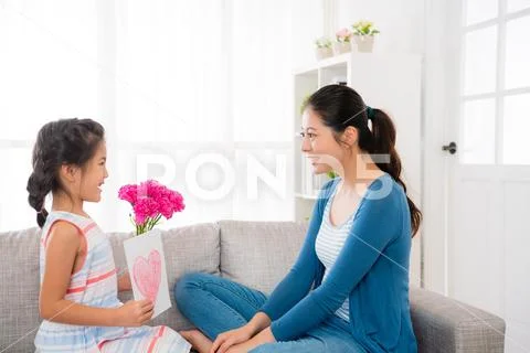 Daughter holding love card and pretty carnation Stock Photos