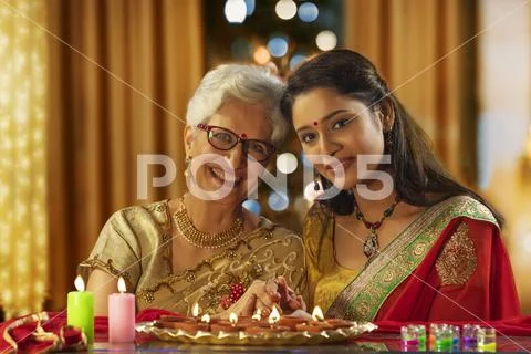 Daughter in law decorating the house with mother in law on the occasion of Stock Photos