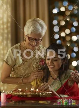 Daughter in law decorating the house with mother in law on the occasion of Stock Photos