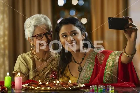 Daughter in law taking a self portrait with mother in law on the occasion of Stock Photos