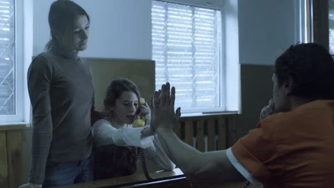 Daughter of a man in jail  talking to him and holding hands Stock Footage 283090783