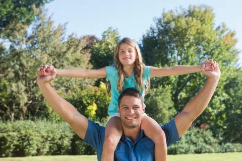 Daughter sitting on dads shoulder Stock Photos