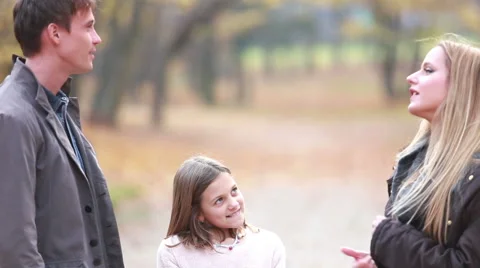 Daughter talking with parents and jumping on the spot in park Stock Footage 59554252