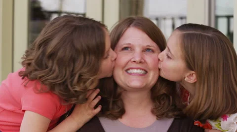 Daughters kiss mom on cheeks | Stock Video