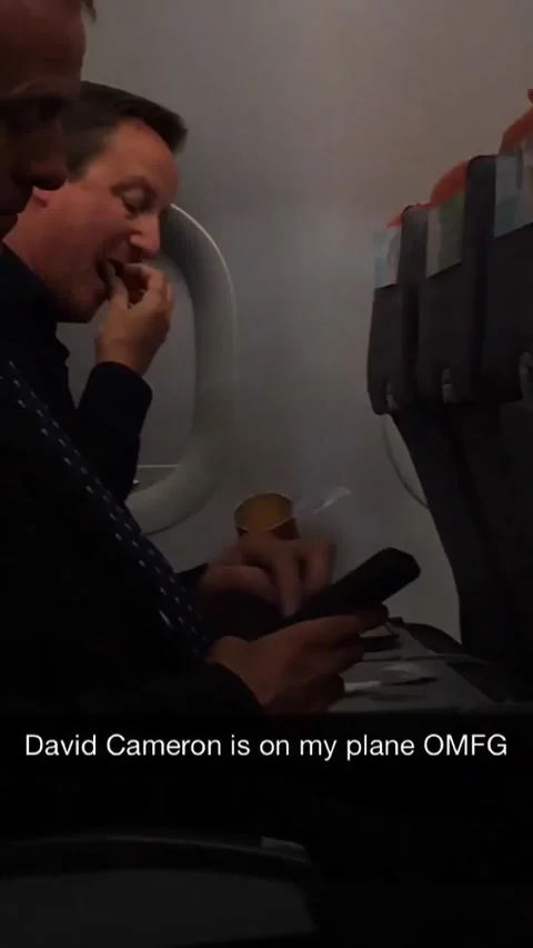 David Cameron enjoys crisps on Easyjet flight Stock Footage 273013224