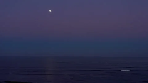 Dawn by the beach with a full moon on top of the ocean Stock Footage 196085580