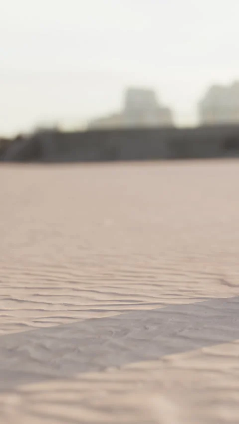 Dawn beach patterns stretch as city buildings rise in the background Stock Footage 338418100