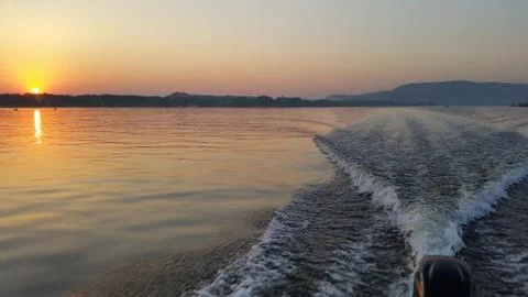 Dawn on the boat while driving the spray from the motor Stock Photos