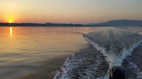 Dawn on the boat while driving the spray from the motor Stock Photos