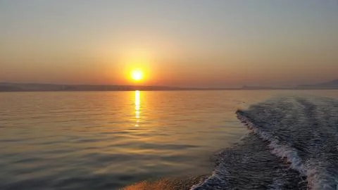 Dawn on the boat while driving the spray from the motor Stock Photos