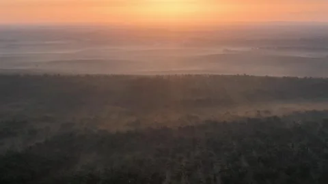Dawn breaks over mist-laced forests Stock Footage 333060127