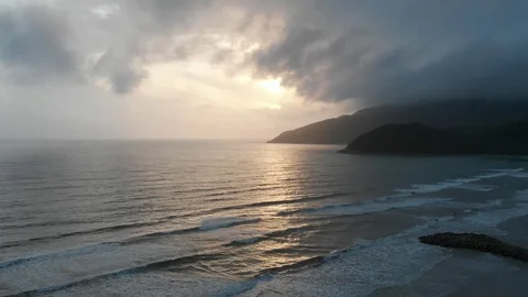 At dawn the flying camera flies beautifully over the beach overlooking the sea 库存影片 100190346