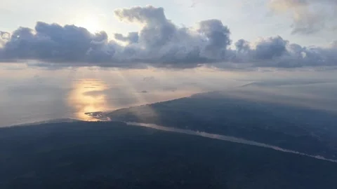 Dawn light breaks through thick, puffy clouds above the sea Stock Footage 337720448