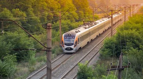 Dawn over the forest through which the railway line runs. Stock Photos