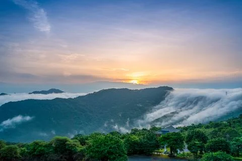 At dawn, the peaceful waterfall of clouds gradually disperses during sunrise. Stock Photos