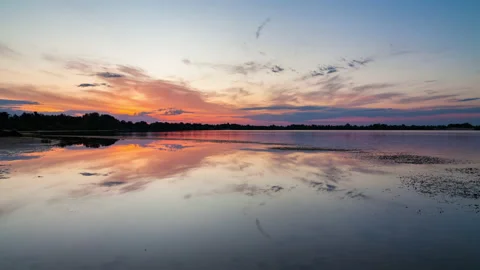 Dawn on a quiet lake. Reflection of clouds in water. Timelapse. Stock Footage 135118612