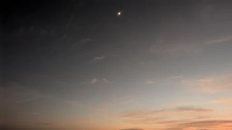 A dawn sky featuring a crescent moon and a soft gradient from dark gray to .. Stock Photos