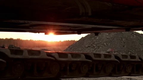 The dawn of the sun between the tracks of a bulldozer at the quarry Stock Footage 163715346