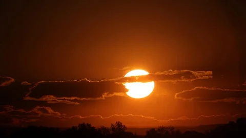 Dawn. The sun comes out from behind the clouds. Smooth disk of the sun. Video stock 122507542