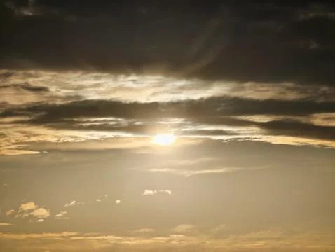 Dawn sun over layered clouds Stock Photos