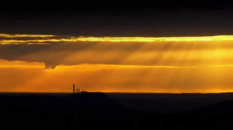 Dawn sun shining through the clouds with construction site in the distance Stock Footage 49042764