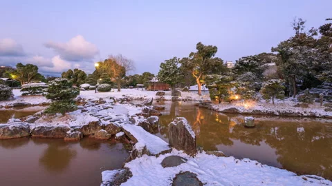 Dawn time lapse of snow covered stone bridge over pond in Japanese garden Vídeo Stock 231447344