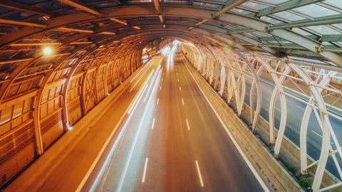 Day and night time lapse traffic light trails speedway steel pipe road tunnel Stock Footage 310066334