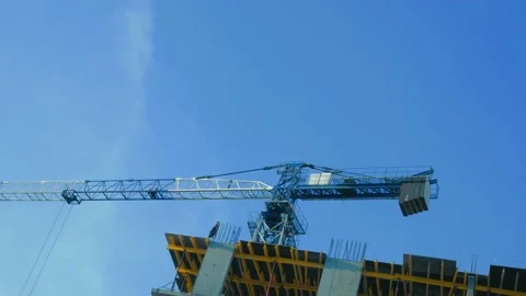 Day, clear sky. The building is under construction. It has a tower crane in Stock Footage 149386722