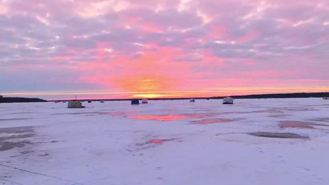 As the day comes to a close, the sun sets brilliantly over a serene frozen lake, Stock Footage 342581665