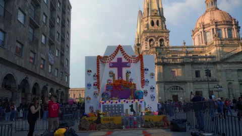 Day of the Dead altar in central plaza with Guadalajara Cathedral at sunset Stock Footage 345179261