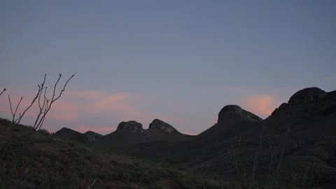 Day to dusk time lapse of thin clouds over rugged peaks Stock Footage 339629004