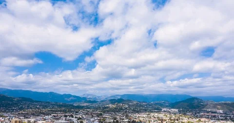 DAY Fast Moving Clouds over MOuntains and City Aerial Timelapse (Hyperlapse) Stock Footage 128845727