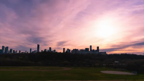DAY TO NIGHT TIME LAPSE OVERLOOKING PARK, PINK CLOUDS AND ORANGE SUN Stock Footage 129176845