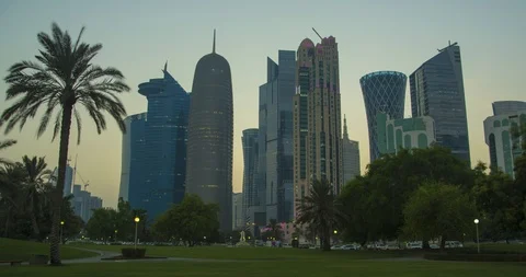 Day to night time lapse of sunset over Doha skyline, qatar, with palm tree Stock Footage 111758772